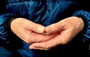 Hands are clasped together, forming a heart shape